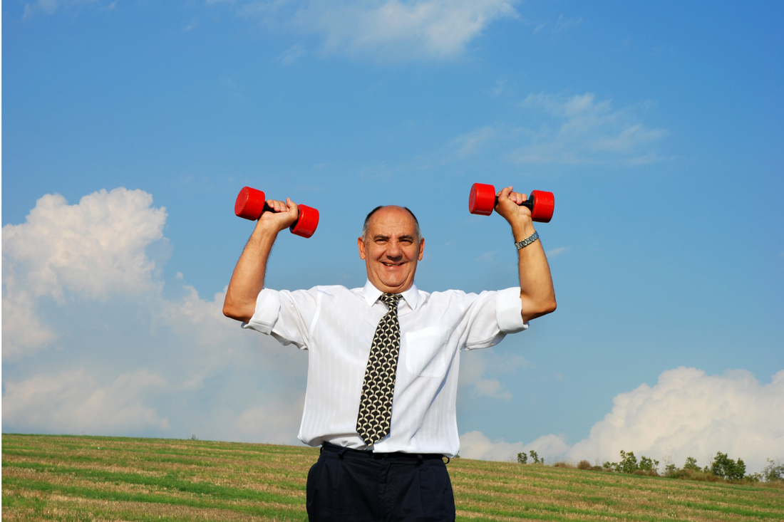 A man in a suit exercising with dumbbells under a blue sky, symbolizing the search for energy or recovery from a hangover.