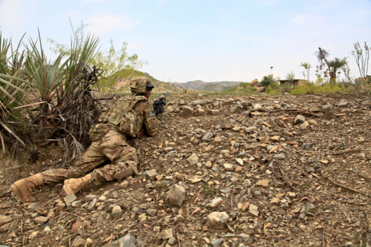 Soldat de l'armée de terre couché regardant au loin dans un état sauvage et camouflé