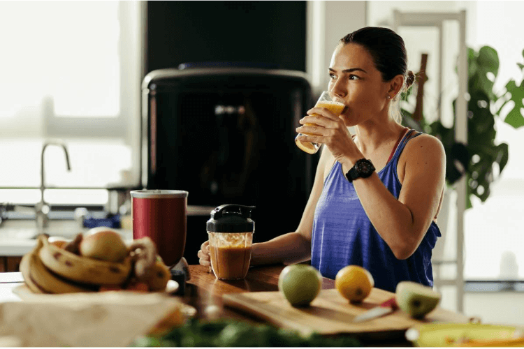 Una mujer bebe zumo de fruta y una solución a base de electrolitos