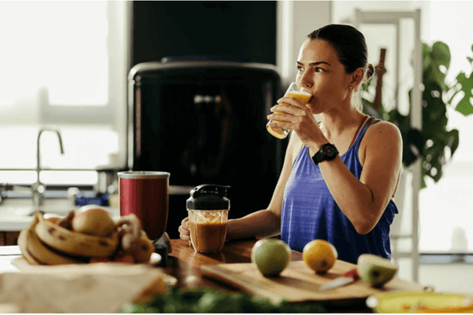 Une femme entrain de boire un jus de fruits et une solution à base d'electrolytes