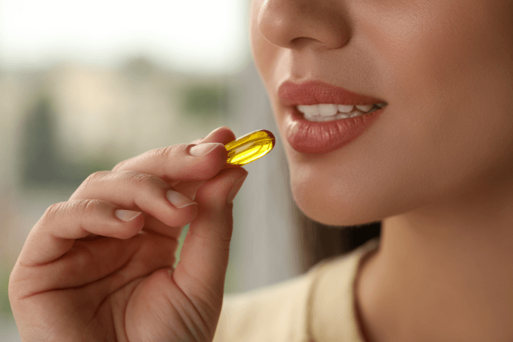 Woman holding a food supplement capsule in her hand, preparing to eat it